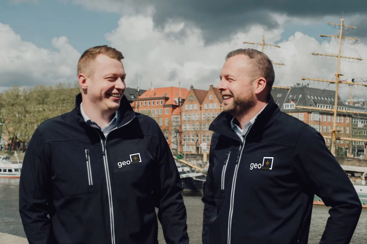 Immobilienmakler Dominik Gröne und Timo Czehowsky aus Bremen stehen draußen an der Weser in der Sonne